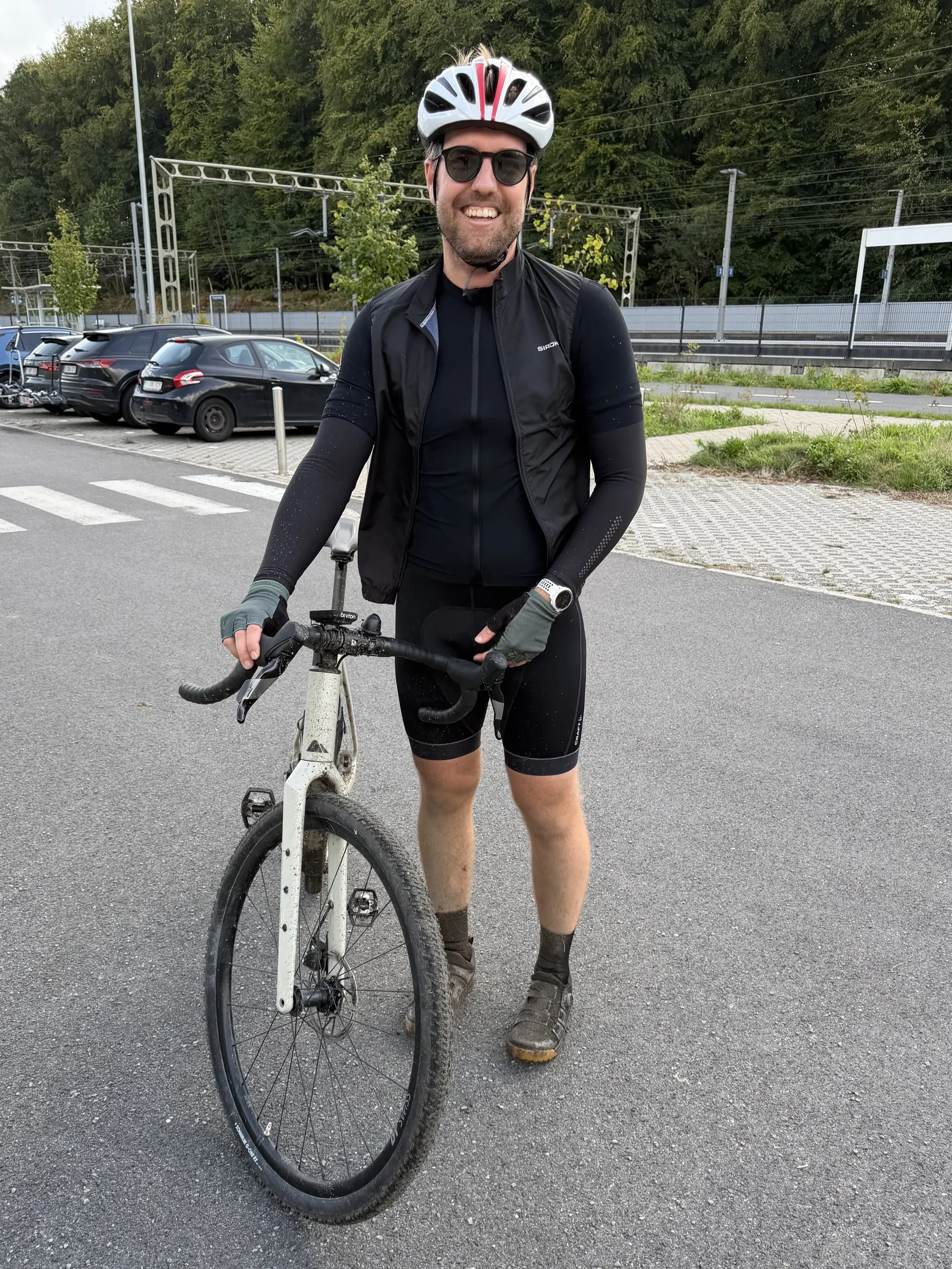 Bram with his gravel bike, in cycling kit and a helmet.